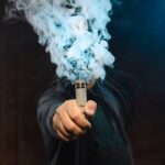 Man som håller i en bolmande vape