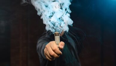 Man som håller i en bolmande vape