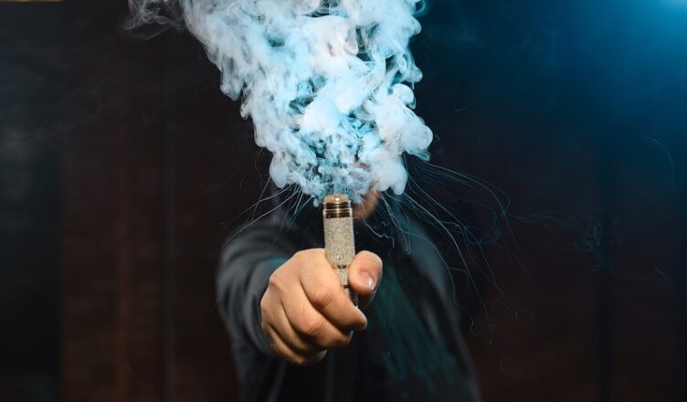 Man som håller i en bolmande vape